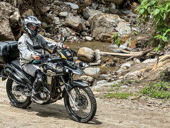 Motorcycle riding through a muddy dirt trail in rural Colombia.Motorcycle riding through a muddy dirt trail in rural Colombia.