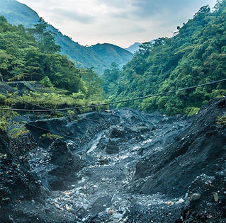 Rough terrain and black soil of the Colombian emerald mining region.