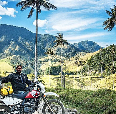 Motorcyclist parked beneath towering wax palm trees in Salamina, Colombia’s Coffee Region.