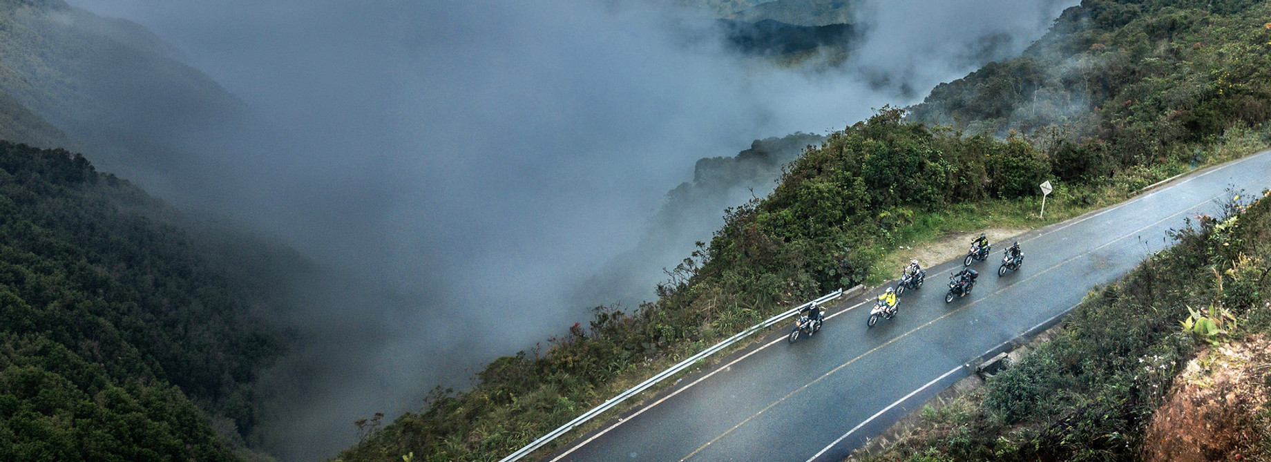 A group of riders passing through the cloudforest during a Colombia motorcycle tour.