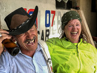 Rider laughing with local man on Medellín motorcycle tour Colombia.