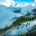 Group of Honda XRE300 adventure motorcycles riding a misty Andean mountain highway in Colombia.