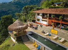 Finca La Manchuria coffee farm with pool, terrace, and traditional Colombian architecture surrounded by green hills.