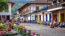 Colorful main square of Jardín with tables, people, and colonial architecture.