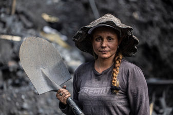 Colombian emerald miner holding a shovel in the black shale mountains of Muzo, Boyacá.