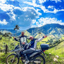 Two motorcyclists on a moto adventure Colombia trip surrounded by wax palms.