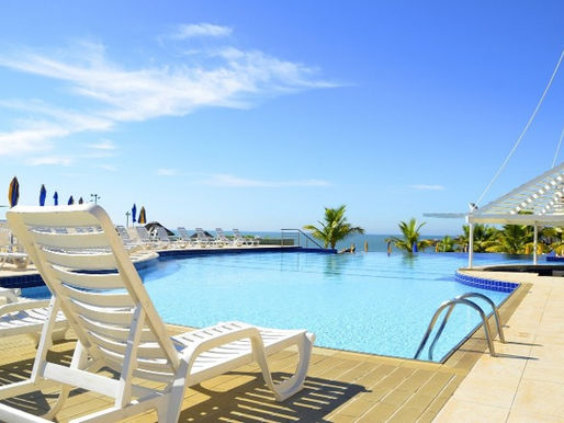 Resort pool landscape with palms and shaded lounge areas at a high-visibility guest amenity