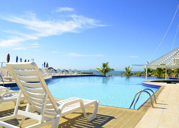 Resort pool landscape with palms and shaded lounge areas at a high-visibility guest amenity