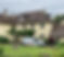 Country house ith roofers outside and a ladder going onto the roof