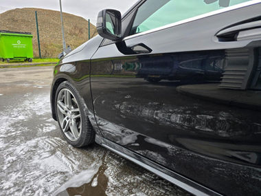 Shiny black car after a foam wash