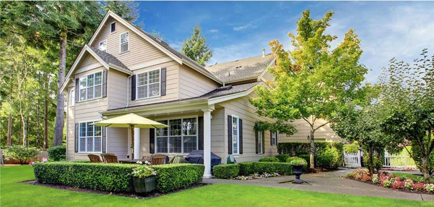 Image of a large home surrounded by lush green landscaping.