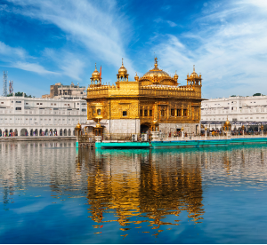 The Golden Temple, a significant Sikh gurdwara in Amritsar, India, shines brightly against the backdrop of the city