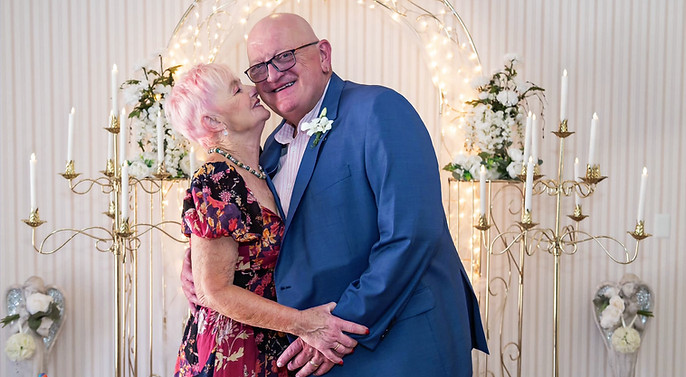 A photo of a sweet moment between two newlywed seniors dancing in the front of the chapel looking blissful.