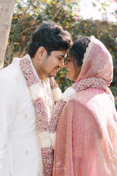 Premium Indian wedding couple photography with elegant floral garlands