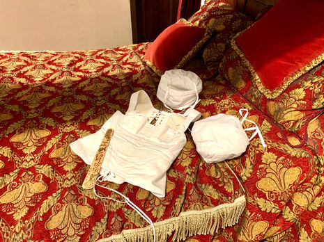 1820s stays/corset, personalised pyrography busk and sleeve supports on Lister's bed.