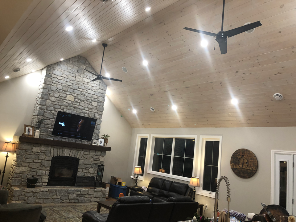 Living room with stone fireplace, wood vaulted ceiling