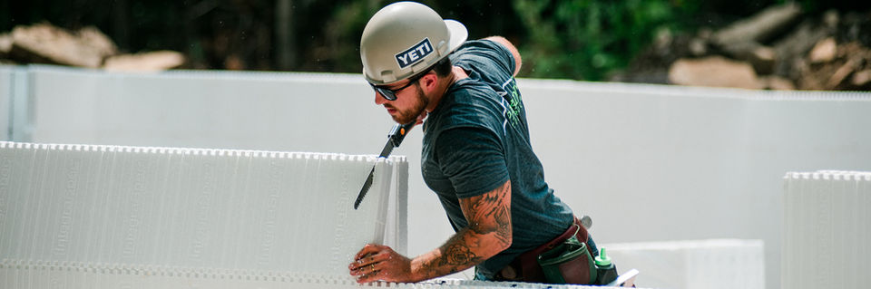 worker in construction site cutting and ICF wall