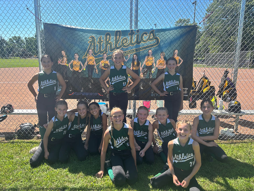 Young softball team posing with Athletics banner.