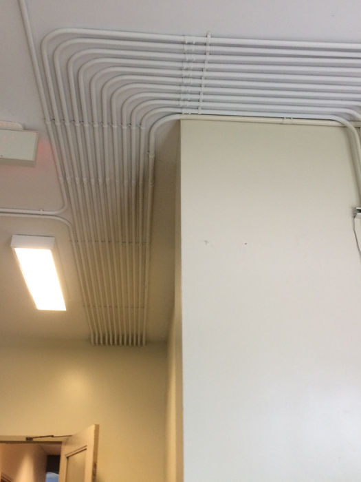 White conduits run along ceiling and wall