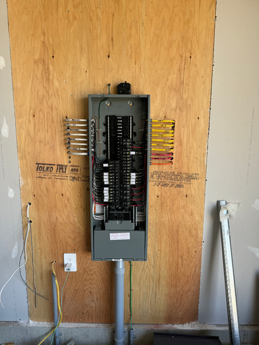 Open electrical panel with wires on a wooden wall