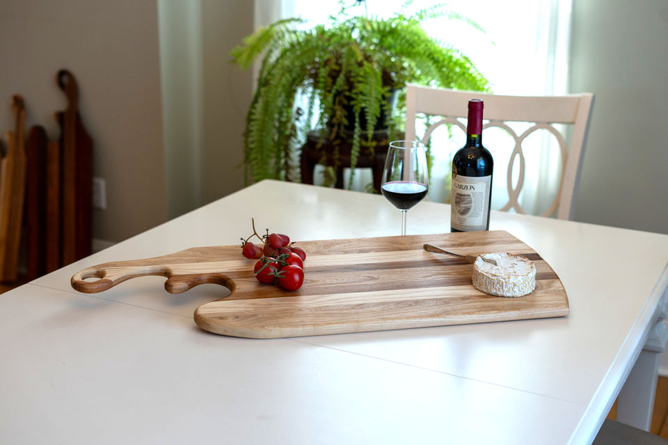 Charcuterie, board with cheese and tomatoes on it.