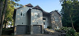 Modern residential home exterior with grey siding and stone.