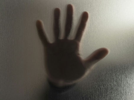 Person placing hands on window, representing clairsentience, intuitive feeling, and spirit communication through the body.