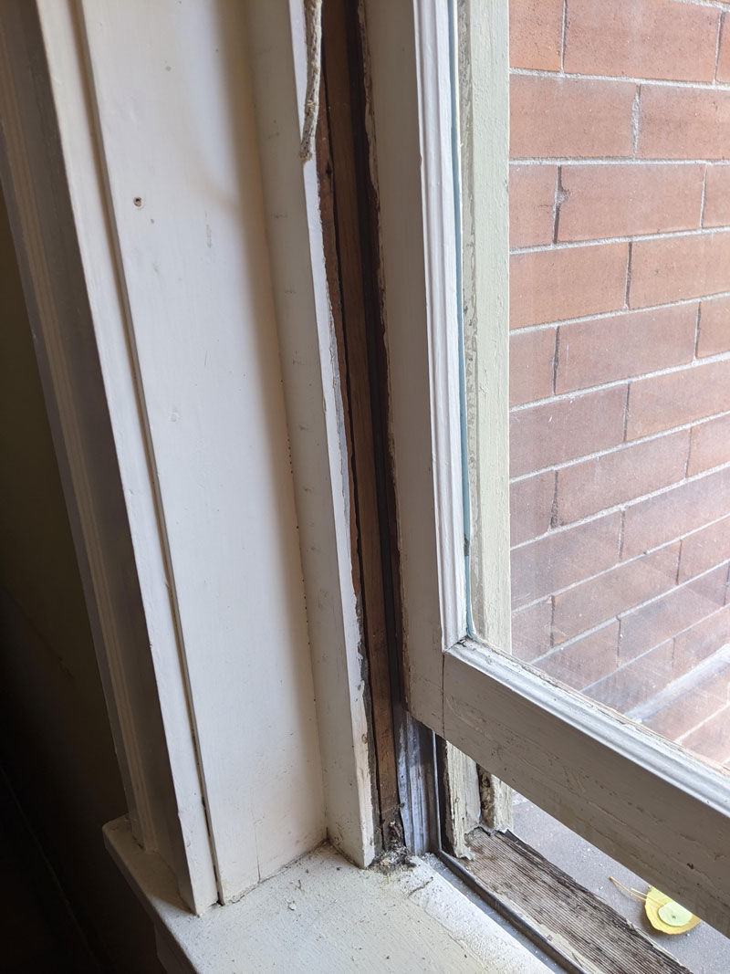 Slide the wooden sash up the metal track to remove the sash from the window