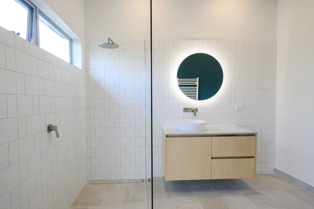 Light and bright round house bathroom with white tiles in the custom home built by Roberts Builders.