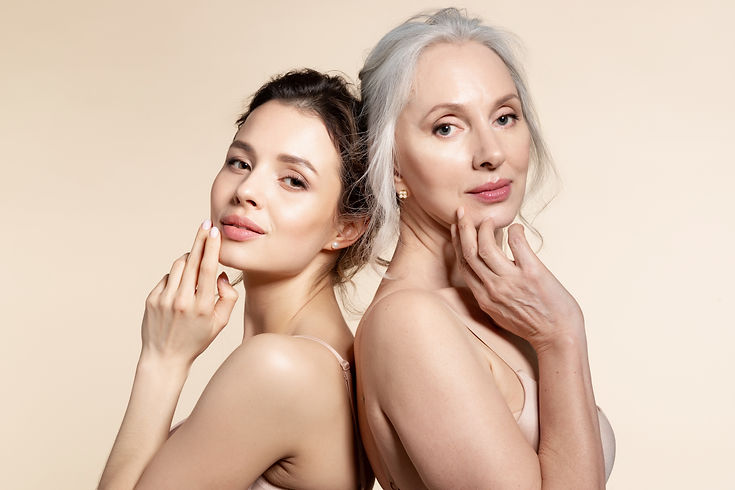 Elderly and young women with smooth skin and natural makeup standing back-to-back. Thinkin