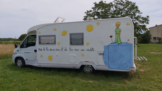Peinture personnalisée du Petit Prince avec citation sur la carrosserie d'un camping-car.