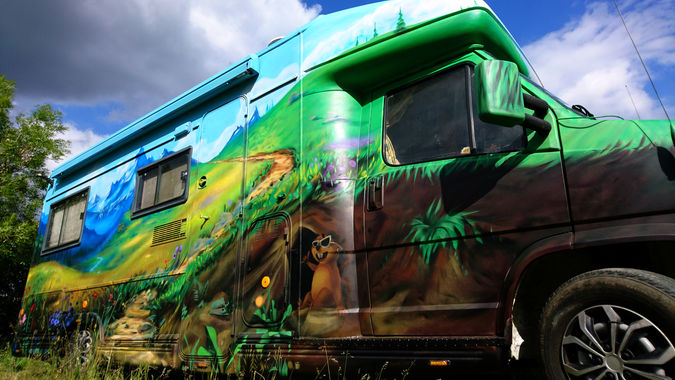 Décoration de carrosserie de camping-car avec une fresque de paysage de montagne et de sommets.