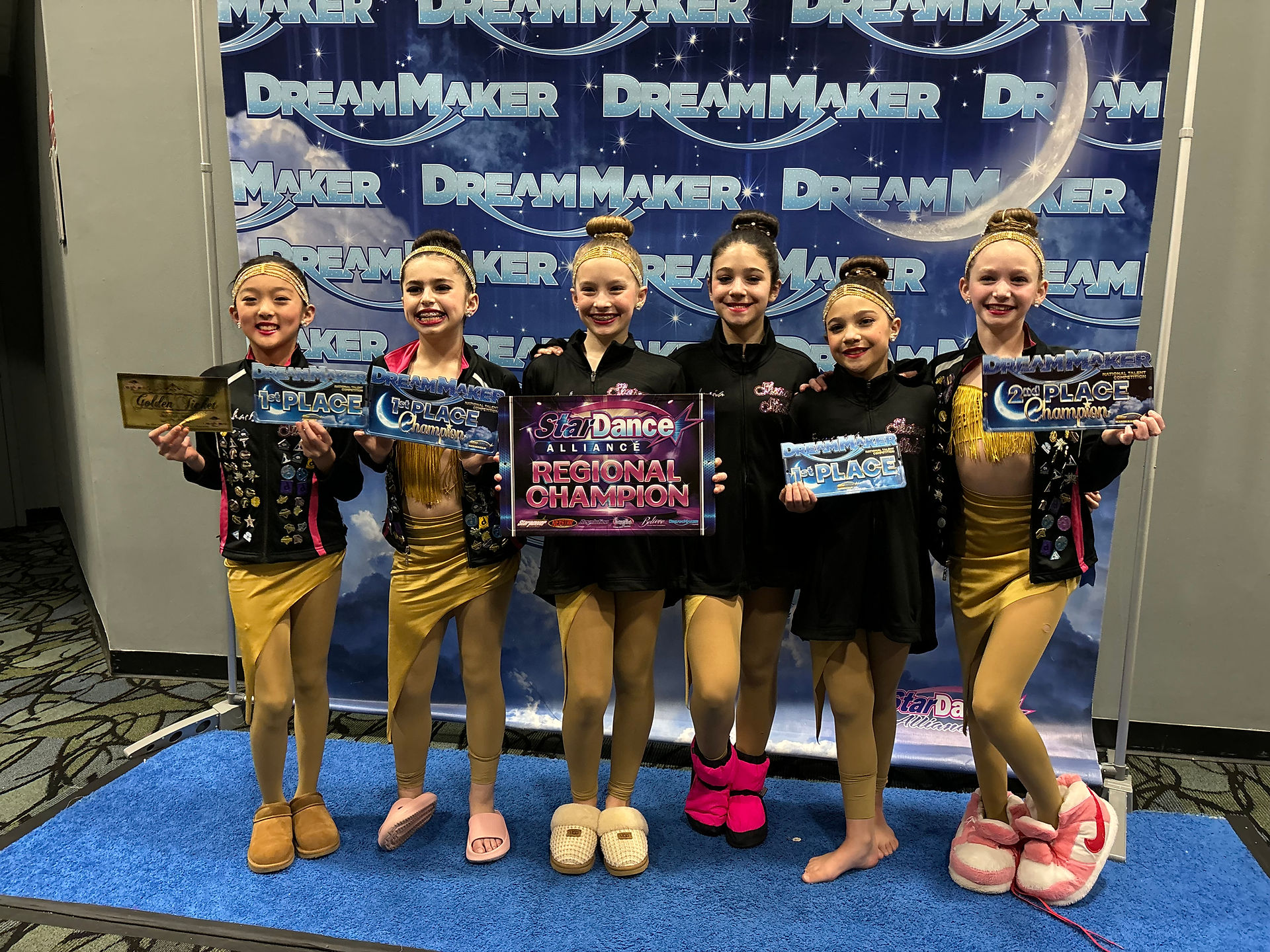 Six young dancers holding trophies, DREAM MAKER banner, Regional Champion in front of them.