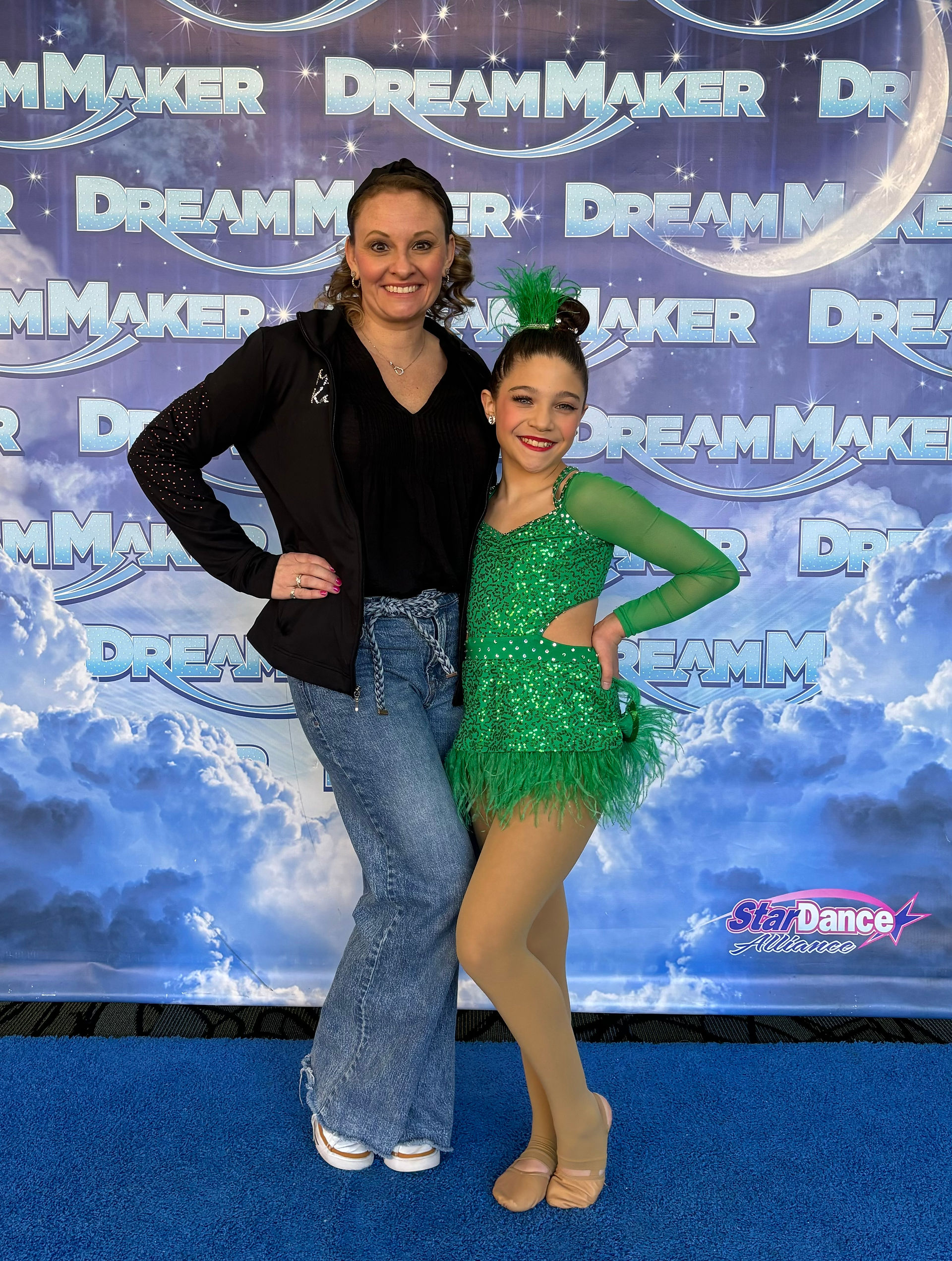 Two dancers posing in front of DREAM MAKER backdrop