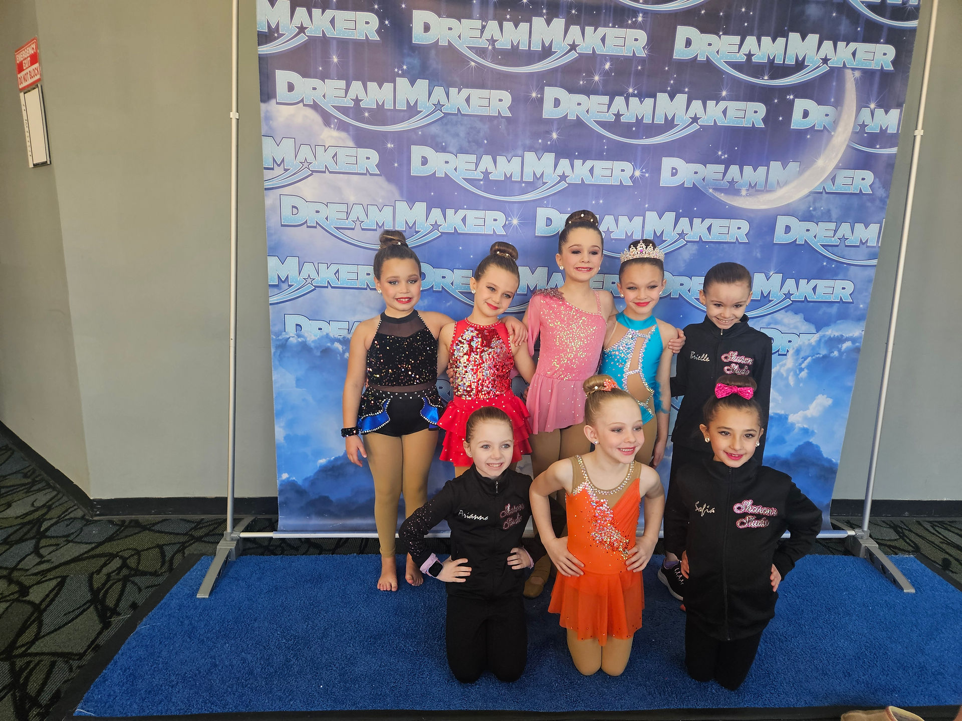 Group of young dancers posing in front of a DreamMaker backdrop.
