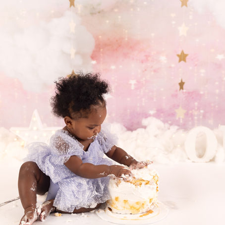 baby girl sitting with cake during cake smash photography session Sydney pink setup