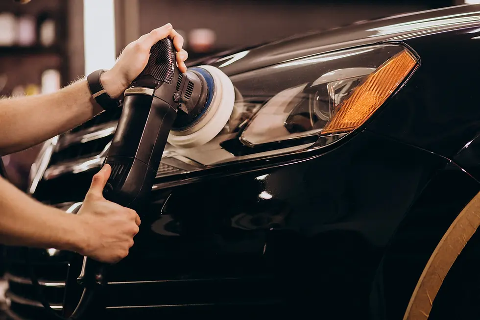 A worker polishing a car headlight