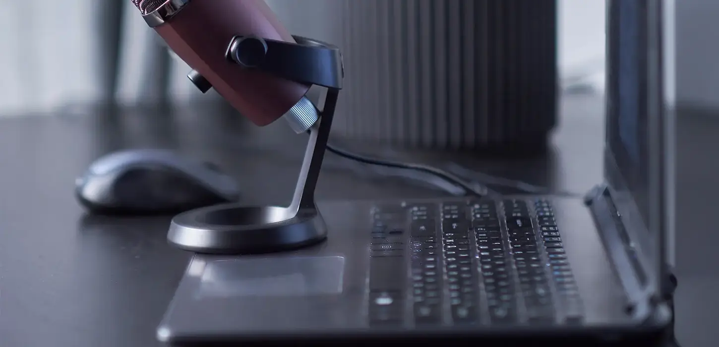 Laptop, smartphone, mikrofon - arbetsplats för podcast