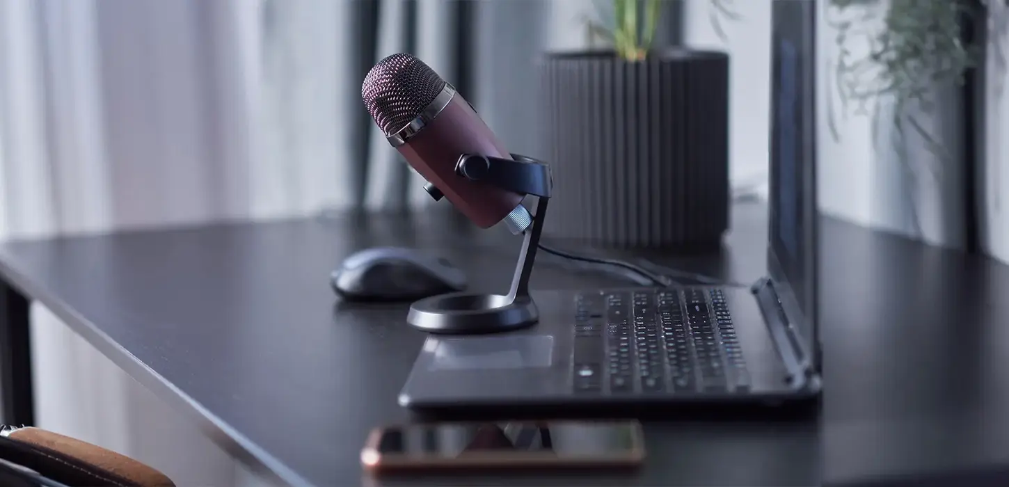 Laptop, smartphone, mikrofon - arbetsplats för podcast