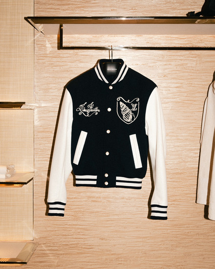 Louis Vuitton black varsity jacket hanging on clothing rack