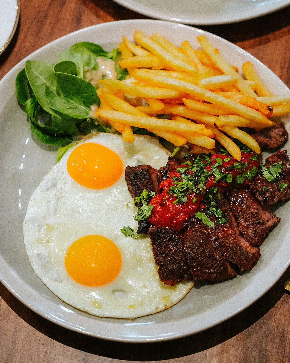 plate of steak and fries with double yolk egg