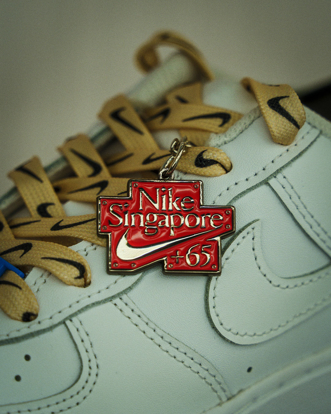 red Nike Singapore +65 charm on lace of NIKE shoe in orchard road store