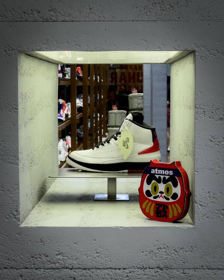 sneaker and daruma doll on display cement block frame in atmos sunway pyramid malaysia