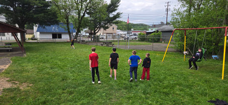 Children playing on a grassy field at a park playground