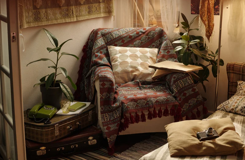 Cozy reading nook with an armchair, plants, books and warm lighting, created as an intentional space for reading, writing and reflection.