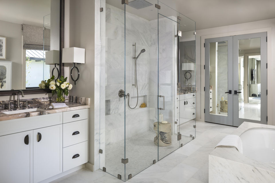 Modern bathroom with glass shower and white cabinets, minimalist design.