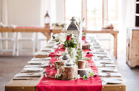 A long banquet table covered in place settings, flowers, candles, and other decorations