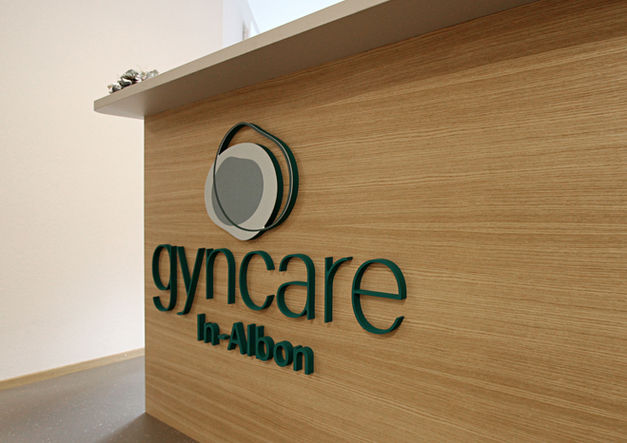 Logo von GynCare In-Albon an der Empfangstheke der Praxis in Visp