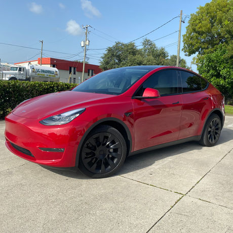 Bright red Tesla sedan with ceramic window tint