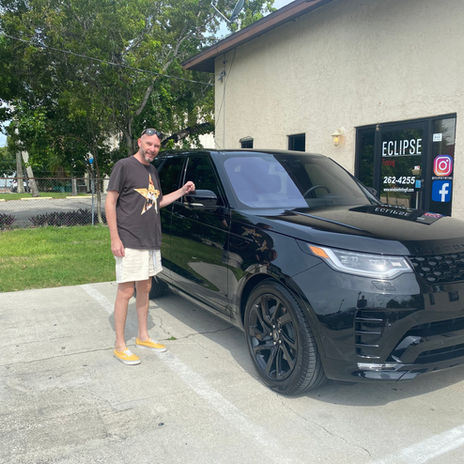 Customer standing next to his newly tinted Range Rover